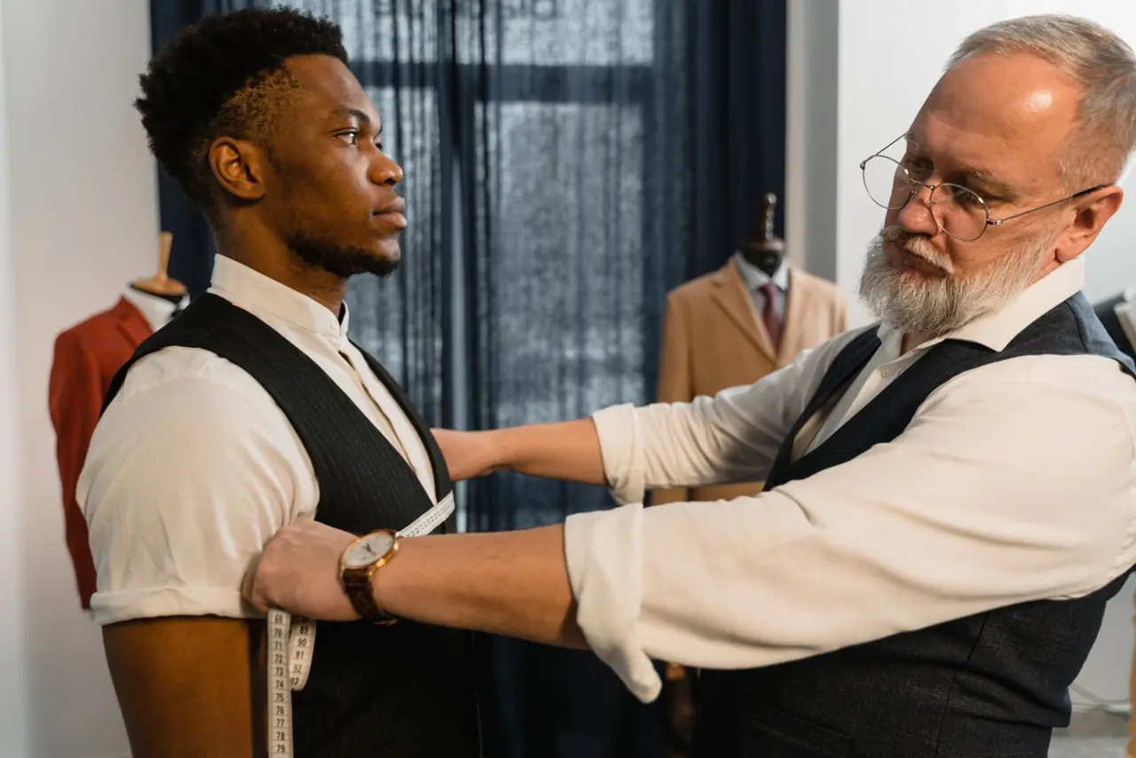 Tailor fitting a client for a suit jacket